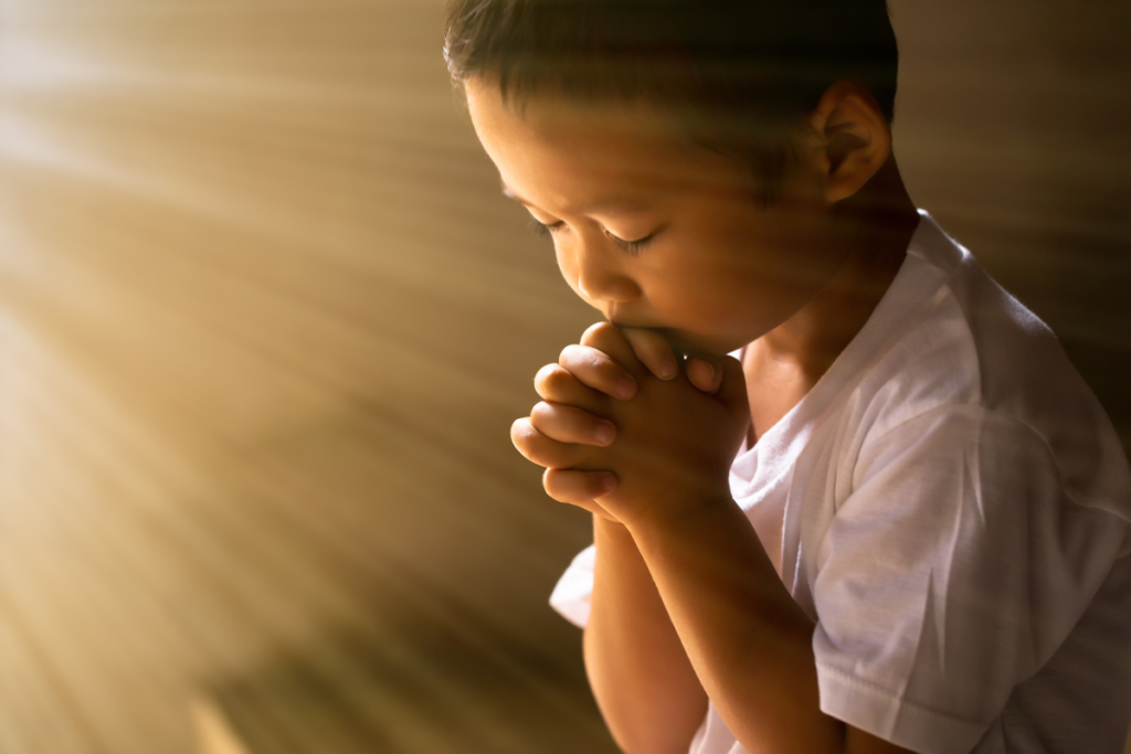 Imagem de uma criança orando com mãos brilhantes, simbolizando a pureza e a conexão divina da oração, como guia no Holy Spirit.